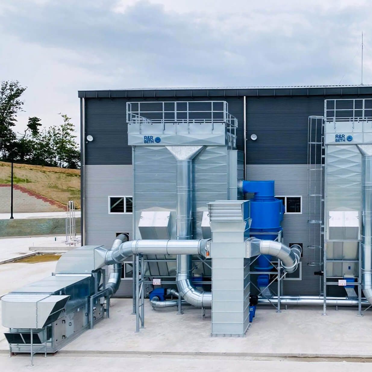 Twin R&R BETH single-line baghouse filters with ducting at a customer plant